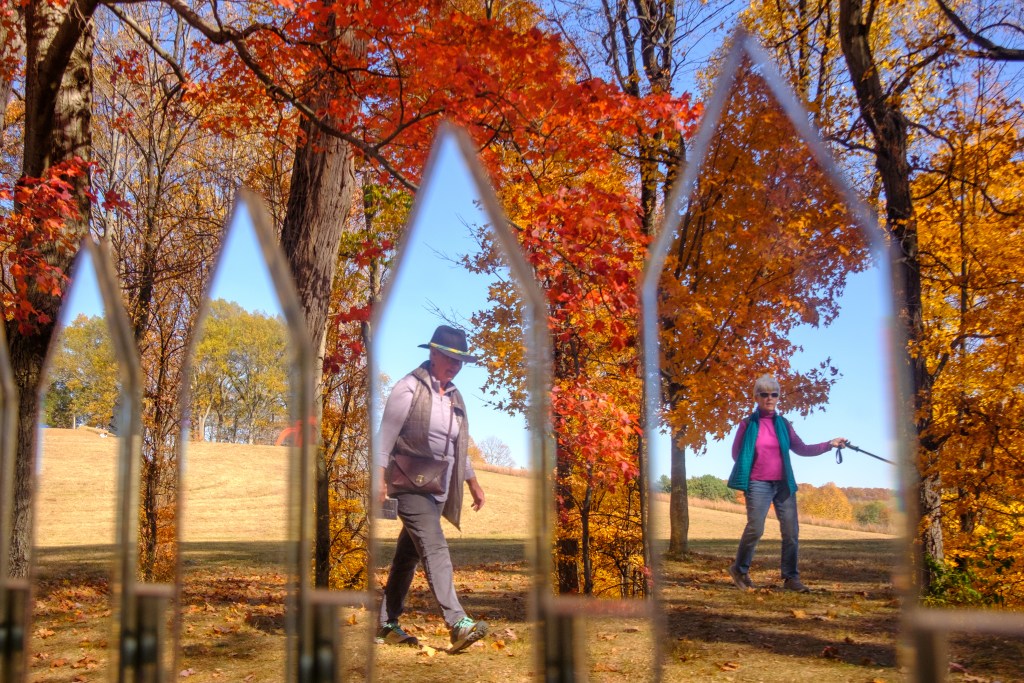 Tobi Watson and Kathy Ambrette reflected on Alyson Shotz's Mirror Fence at the Storm King Art Center amid the autumn leaves.